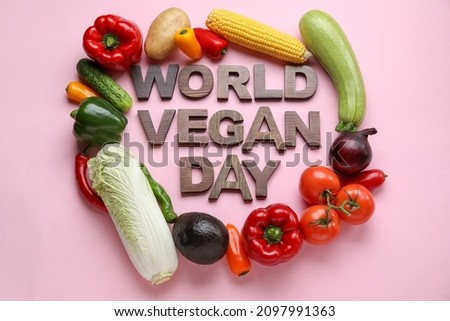 Text WORLD VEGAN DAY made of wooden letters and vegetables on color background