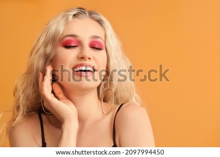 Young woman with beautiful eyeshadows on color background Royalty-Free Stock Photo #2097994450