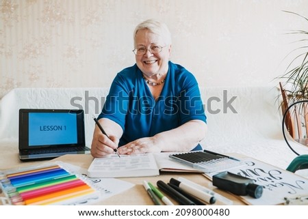 Hobby Ideas for Older People. Retirement Hobbies, Pastimes for Seniors. Activities for Seniors with Limited Mobility. Mature, elderly Senior Female Artist practices calligraphy and hand lettering Royalty-Free Stock Photo #2098000480