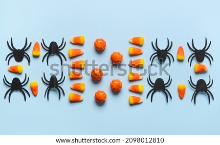Halloween candies with spiders on blue background