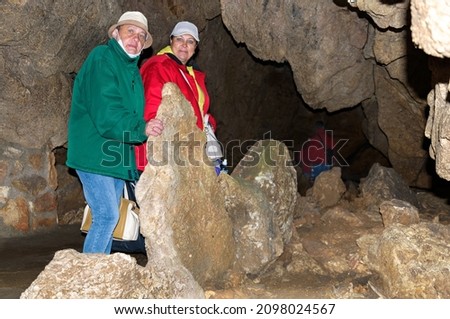 Two women, members of the tourist group, pose against the backdrop of the cave.