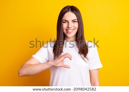 Photo of young pretty girl show fingers half of heart cupid feelings isolated over yellow color background