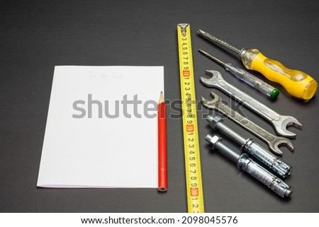 a sheet of paper and a different tool on a black background. space for printing text. background picture.