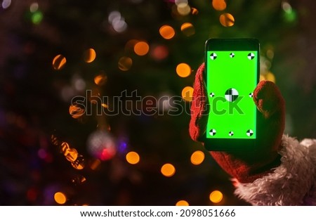 Santa claus holding phone in hand. Green chroma key for your AD.
