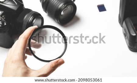 filter lenses in hand, photo equipment, photo accessories. white table background