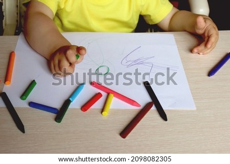 Cropped portrait of young child drawing picture with colored pencils, copy space