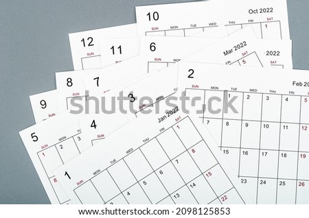 Many blank monthly 2022 calendar sheets on grey background.
