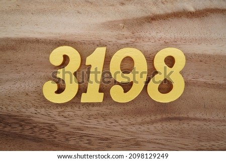 Golden Arabic numerals 3198 on a dark brown to white wood grain background.