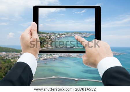 Businessman hands tablet taking pictures beach and sea on cloud