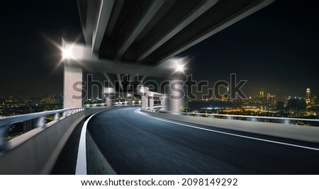 Highway overpass with modern city skyline background. Night scene