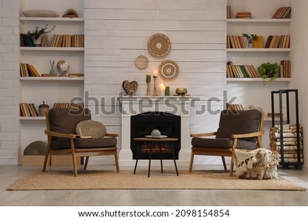 Cozy living room interior with comfortable armchairs near fireplace