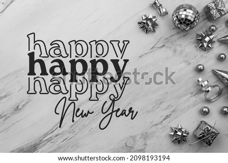 Happy New Year text script with festive silver decorations on white marble background