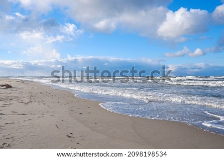 blue Baltic sea against the background of blue sky on a sandy beach on the Curonian Spit in winter in the Kaliningrad region