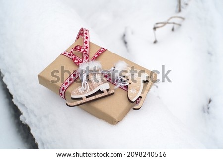 gift box, toy wooden skates in the snow