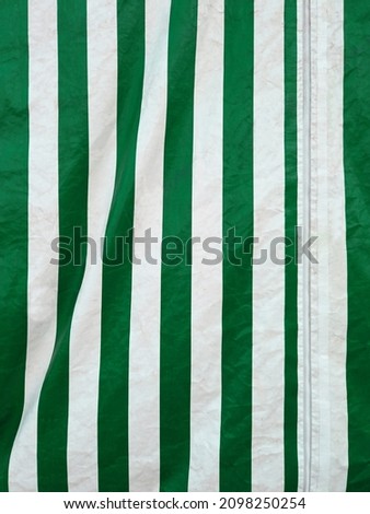 Full frame striped canvas. Vertical green and white striped awning fabric texture. Vertical striped fabric background. Striped outdoor fabric. Royalty-Free Stock Photo #2098250254