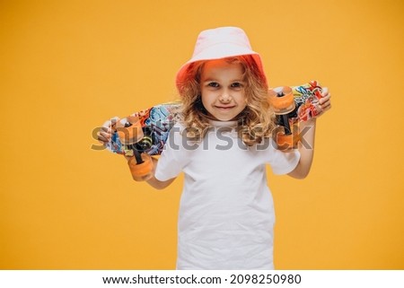 Cute little girl with skate board isolated in studio