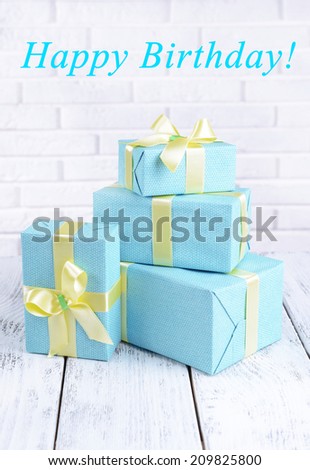Beautiful gifts on table on brick wall background