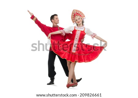 Couple of dancers in russian traditional costumes, girl in red sarafan and kokoshnik, boy in black trousers and red shirt .  Studio shot isolated on white. 