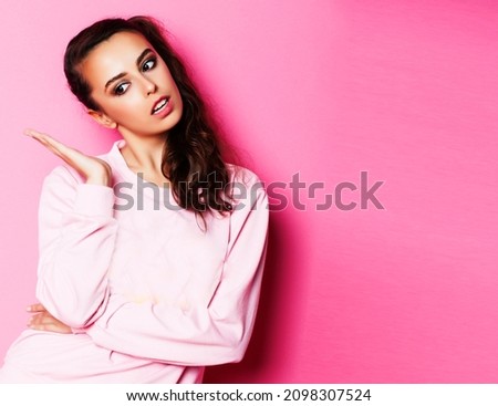 young pretty teenage girl emotional posing on pink background, fashion lifestyle people concept close up copyspace