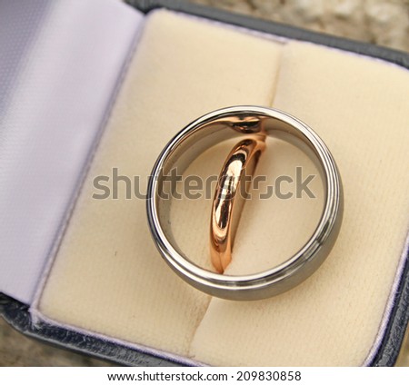 Bride and groom contrasting wedding rings in a presentation box