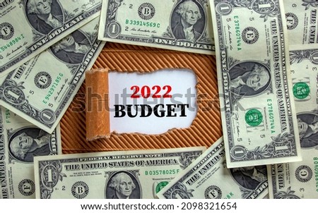 2022 budget new year symbol. Words '2022 budget' appearing behind torn brown paper. Beautiful background from dollar bills. Business, 2022 budget new year concept, copy space.