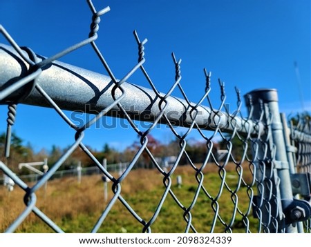 A closeup shot of the top of a fence. The top of the gate has twisted pieces of metal that fork out and are super sharp. Royalty-Free Stock Photo #2098324339