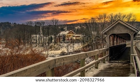 Landscape photo of Stowe Vermont. Photo is capturing the covered bridge with the town of Stowe Vermont. A winter background.