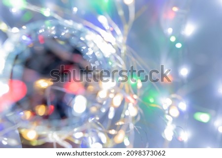 Colored shiny ball with lens flares and bokeh effect from colored lights on gray background