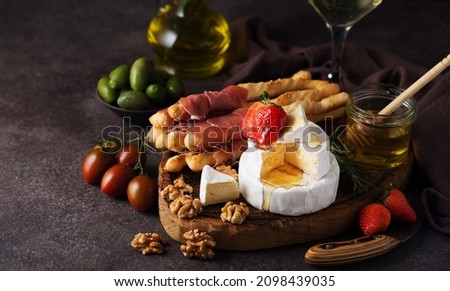 Brie cheese, camembert, grissini, jamon, wine, nuts, honey. Snacks for wine. Italian snacks Royalty-Free Stock Photo #2098439035