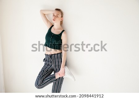 fashionable blonde woman in green clothes