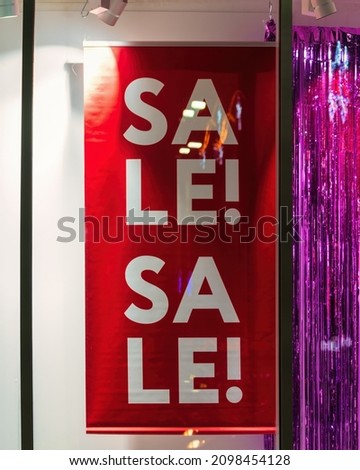 Signboard sale on a shop window at night illuminated by backlight. Cyber Monday and black Friday or celebrating sales concept.     