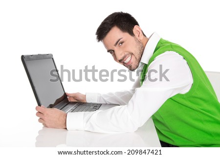 Isolated happy business man in green holding his laptop.