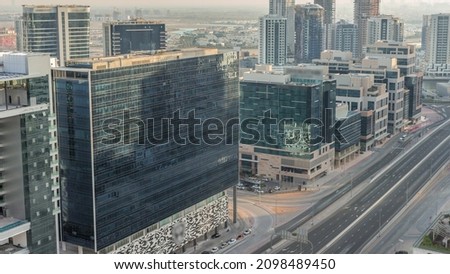 Dubai's business bay office towers aerial timelapse. Rooftop view of some skyscrapers and new buildings under construction. Traffic on the road