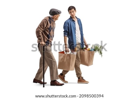 Young man carrying grocery bags and walking with a senior man isolated on white background Royalty-Free Stock Photo #2098500394