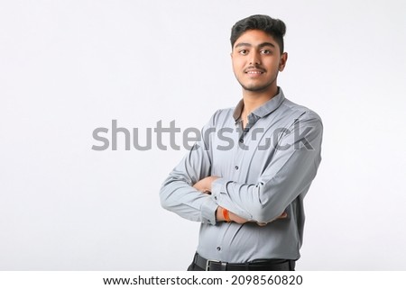 Successful Young indian business man posing over white background.