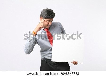Young Indian business executive showing blank sign board over white background.