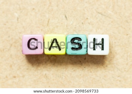 Color alphabet letter block in word cash on wood background