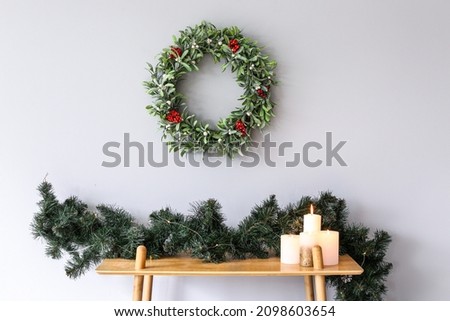Beautiful mistletoe wreath with Christmas decor on table in room