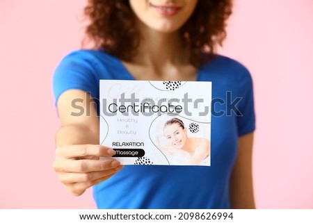 Pretty young woman with gift certificate on pink background, closeup