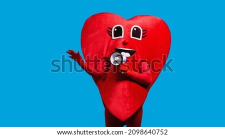 person in happy heart costume holding loudspeaker isolated on blue