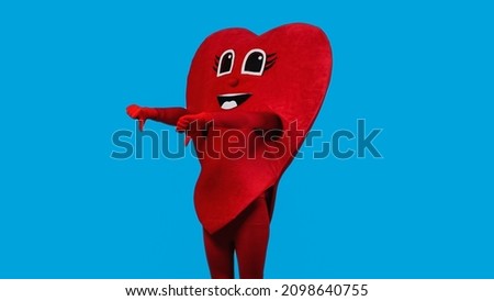 person in red heart costume showing thumbs down isolated on blue