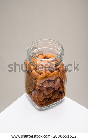 Glass jar filled with a variety of nutrition and healthy snacks and nuts on a dark background
