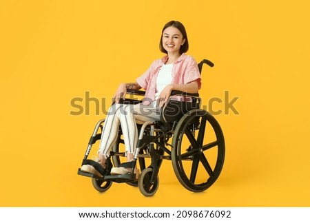 Young woman in wheelchair on color background Royalty-Free Stock Photo #2098676092