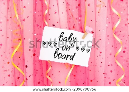 Baby on board - card with glittering pink colorful background and decorations and hearts