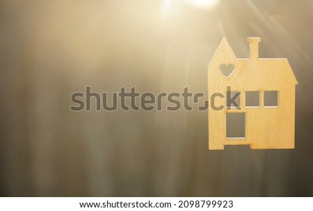 wooden house model against sunset light for sale or rent, family home and shelter concept, real estate, solar energy and eco accommodation