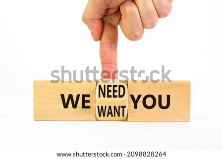 We want and need you symbol. Businessman turns the wooden cube and changes words we want you to we need you. Beautiful white background, copy space. Business, support we want and need you concept.