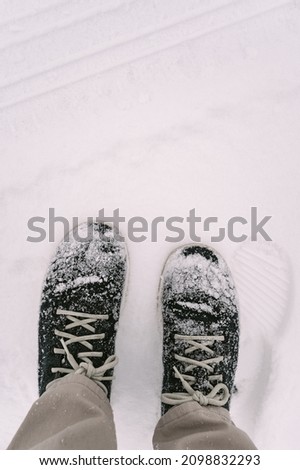 Man standing in snow covered boots after snow storm