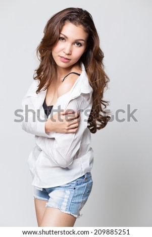 Beautiful brunette girl in jeans and white  on white background