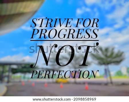 Inspirational life quote "STRIVE FOR PROGRESS NOT PERFECTION" isolated on a blurry background.