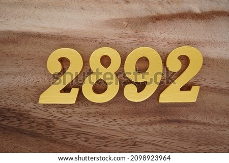Golden Arabic numerals 2892 on a dark brown to white wood grain background.